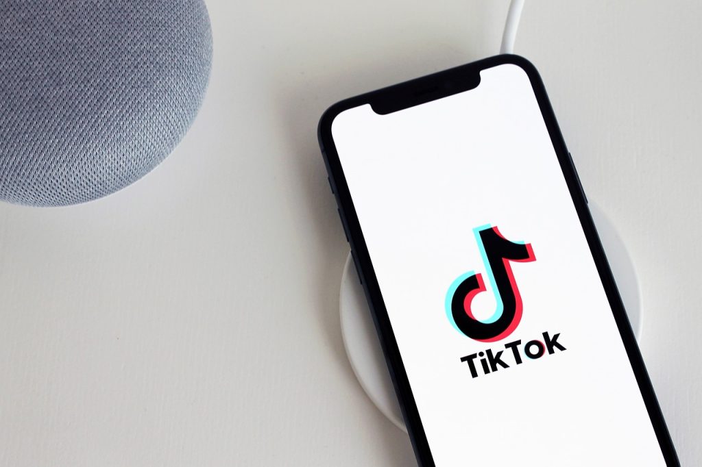 Smartphone displaying the TikTok app logo on a wireless charger, highlighting TikTok management services.
